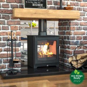 Hazelwood Double Side Wood Burning Stove with large glass window set in a brick fireplace with wooden mantel and firewood storage, Cork, Homexpert