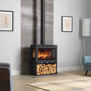 Charlton & Jenrick PureVision LPV8 black wood-burning stove with three-sided panoramic glass, glowing flames and dedicated log store in a modern living room, Cork, Homexpert