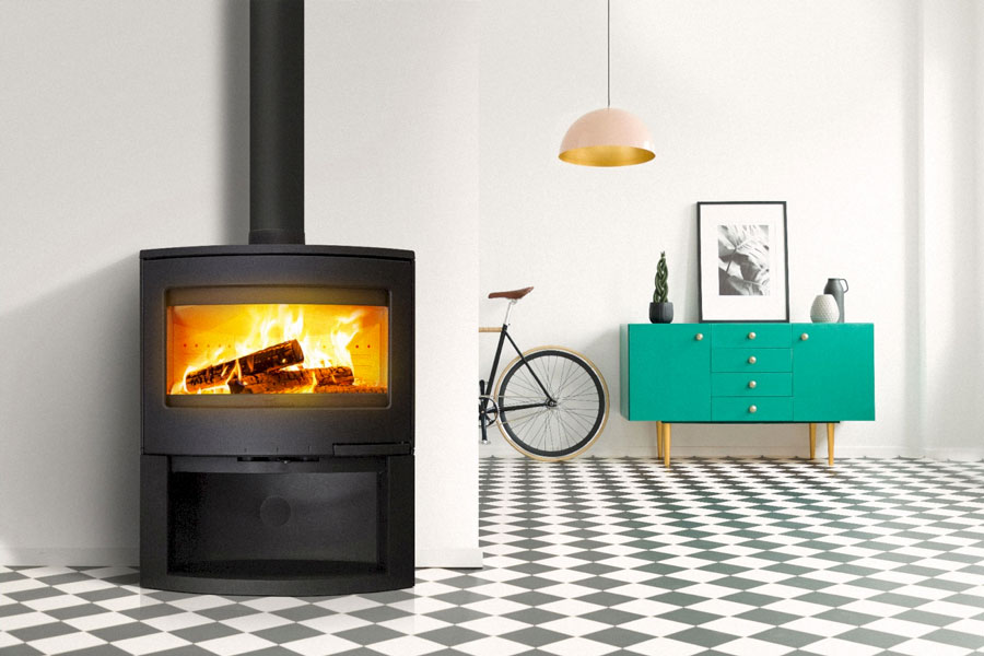 LACUNZA Bristol cast iron fireplace wood-burning with a large glowing fire, black finish, glass door and black flue in a bright modern interior, Cork, Homexpert