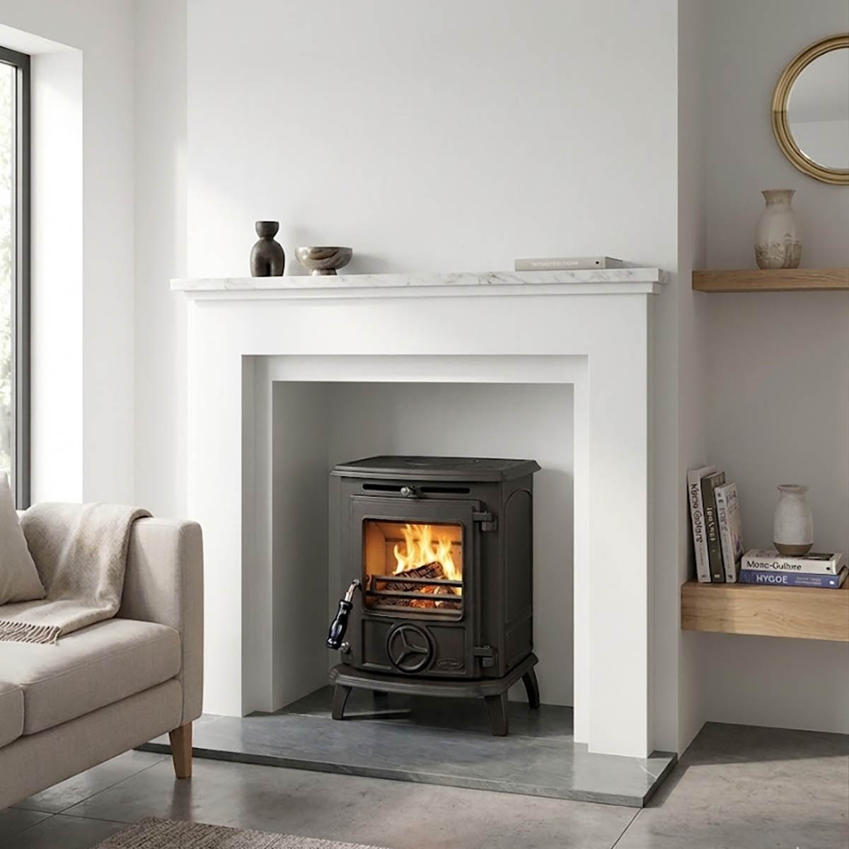 Stanley Oisin Matt Black solid fuel stove with flames burning inside, installed within a white fireplace surround with a marble hearth in a bright modern living room, Cork, Homexpert