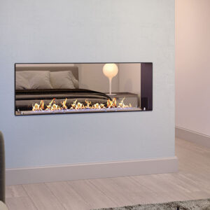 A double-sided, see-through Lumin DC bioethanol fireplace built into a central divider wall, showcasing a linear flame that bridges a living room in the foreground with a bedroom visible in the background. Cork, Homexpert