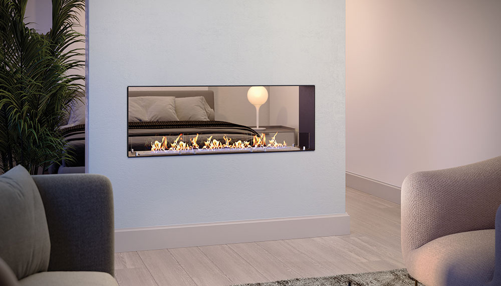 A double-sided, see-through Lumin DC bioethanol fireplace built into a central divider wall, showcasing a linear flame that bridges a living room in the foreground with a bedroom visible in the background. Cork, Homexpert