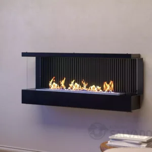 A black, three-sided wall-mounted bioethanol fireplace LUMIN 1100 Mural showcasing active linear flames against a modern, slatted black interior backing, mounted on a plain off-white wall. Cork, Homexpert